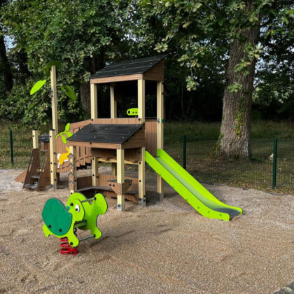 Aire de jeu avec toboggan vert sur un sol de gravillon et tortue à ressort pour enfants