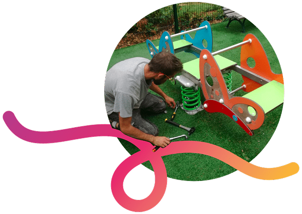Un technicien répare un jeu à bascule pour enfant