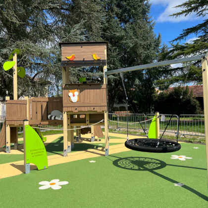 Aire de jeux parc public, avec balancelle, toboggan et jeu de cordage. Message d'attention de sécurité.